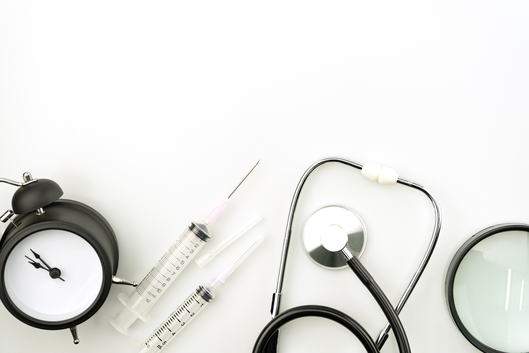 Medical Equipment and Alarm Clock on White Background Copy Space